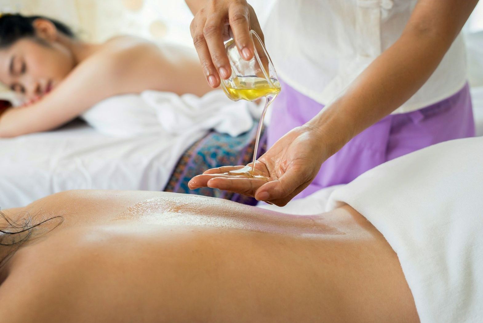 Spa treatment in progress with massage oil being poured